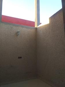 um quarto vazio com uma janela e uma parede em Appartement à louer Tiznit 2 em Tiznit