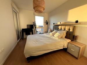een slaapkamer met een groot bed en een bureau bij Location for Olympic Games (JO) in Houilles