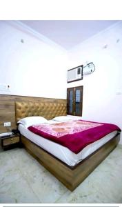 New hotel blue stars في فاراناسي: غرفة نوم بسرير كبير مع بطانية ارجوانية