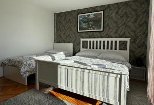 1 dormitorio con 2 camas y pared en Guest House Aurora en Poljanak