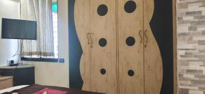 un armario de madera con círculos en un dormitorio en P N A Apartments, en Kālva