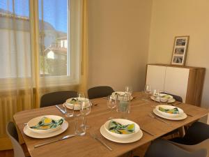 einem Holztisch mit Tellern und Gläsern darauf in der Unterkunft Ascona Casa Farfalla 1 in Ascona