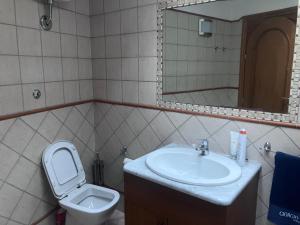 Un baño con lavabo, inodoro y espejo. en Pigneto liberty house, en Roma 6 fotos más