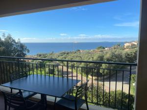 balkon ze stołem i krzesłami oraz oceanem w obiekcie Creste E Mare w Ajaccio
