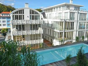 オストゼーバート・ゼリンにあるVilla "Johanna" Sellin - WG11 mit Kamin und großer Terrasseのアパートメントの建物の正面にスイミングプールがあります。