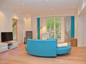 a blue couch in a living room with a tv at Villa "Johanna" Sellin - WG11 mit Kamin und großer Terrasse in Ostseebad Sellin