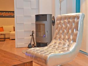 a silver leather chair in a living room with a tv at Villa "Johanna" Sellin - WG11 mit Kamin und großer Terrasse in Ostseebad Sellin