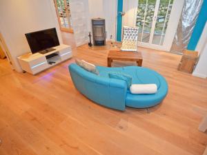 a living room with a blue couch and a television at Villa "Johanna" Sellin - WG11 mit Kamin und großer Terrasse in Ostseebad Sellin +34 photos