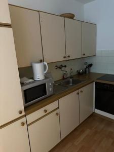 a kitchen with a sink and a microwave at Apartment4 you in Vienna
