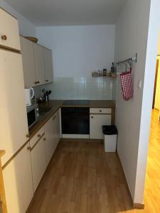 a kitchen with white cabinets and a black dishwasher at Apartment4 you in Vienna