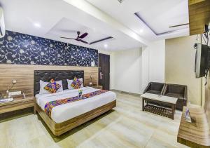 ein Schlafzimmer mit einem großen Bett und einem TV in der Unterkunft Prashant Hotel Indore in Indore
