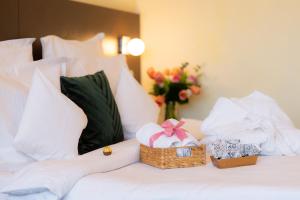 een bed met een mand met cadeautjes en een vaas met bloemen bij Hotel Terra Balneo&Spa in Galaţi