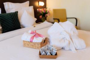 a hotel room with towels and a basket on a bed at Hotel Terra Balneo&Spa in Galaţi
