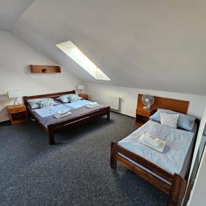 a bedroom with two beds and a skylight at Penzion a Restaurace Simanda in Prague +130 photos