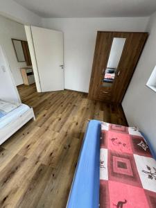 una camera con letto e pavimento in legno di City Villa Bad Dürrheim a Bad Dürrheim