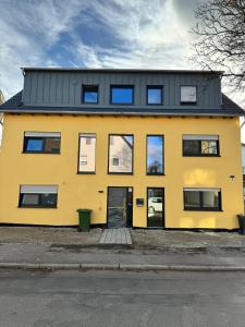 un edificio giallo con tetto nero di City Villa Bad Dürrheim a Bad Dürrheim
