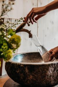osoba myje szklankę w zlewie w obiekcie Werdenfelserei w Garmisch Partenkirchen