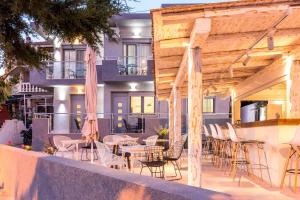 een patio met tafels en stoelen en een gebouw bij Lena Apartments Potos in Potos