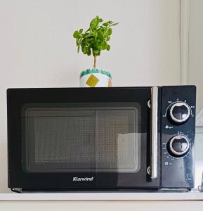 a black microwave with a plant on top of it at With us house in Ansan