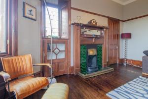 a living room with a fireplace and a chair at Pass the Keys Beautiful, traditional 2 bed flat w free parking in Glasgow