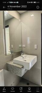 a bathroom with a white sink and a mirror at Le Palis Suite 