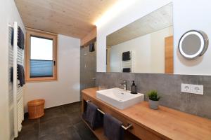 La salle de bains est pourvue d'un lavabo et d'un miroir. dans l'établissement Straußberghof, à Riezlern