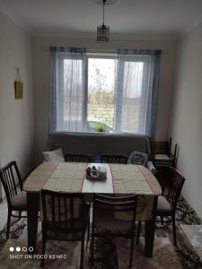 a dining room with a table and chairs and a window at CiciHome in Qusar