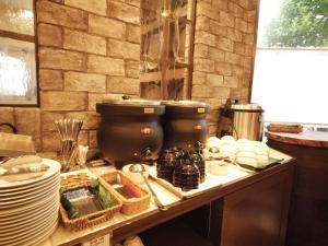 a kitchen with a counter with plates and dishes on it at HOTEL MYSTAYS Kameido in Tokyo