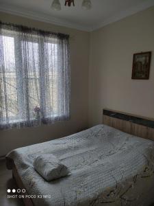 a bed in a bedroom with two large windows at CiciHome in Qusar