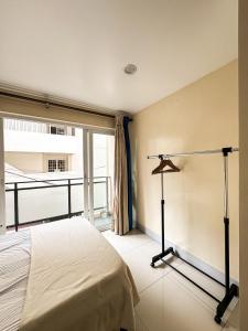 een slaapkamer met een bed en een groot raam bij Megatower 1 Residences, Condominium Transient in Baguio