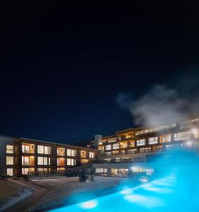 un edificio con piscina por la noche en Hirben Naturlaub, en Villabassa