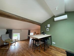 cocina con mesa y sillas en una habitación en Appartement Cosy sous les toits, en Pont-d'Ain