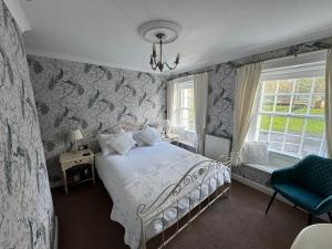 um quarto com uma cama e uma cadeira azul em Brunswick House em Middleton in Teesdale