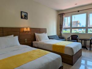 um quarto de hotel com duas camas e uma janela em 中青秋果酒店 True Go Hotel em Phnom Penh