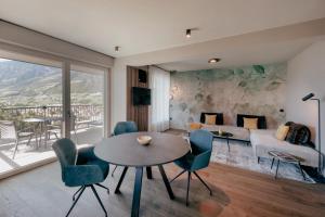 - un salon avec une table, des chaises et un canapé dans l'établissement LA LIBELLA - slow living Suites, à Merano