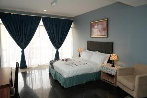 a bedroom with a bed and a couch and a chair at Putera Island Resort in Melaka