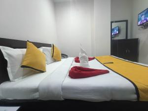 a large white bed with yellow and red pillows at hotel city, Star Hotels & Resorts, Amritsar in Amritsar
