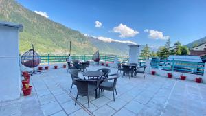 un grupo de mesas y sillas en un patio en Hotel Himalayan Meadows, en Manali