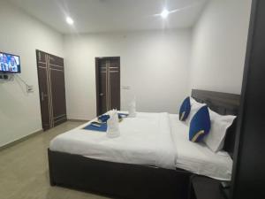 a bedroom with a large bed with blue and white pillows at hotel city, Star Hotels & Resorts, Amritsar in Amritsar