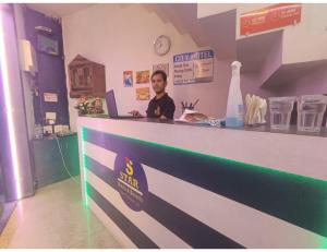 アムリトサルにあるhotel city, Star Hotels & Resorts, Amritsarの店のカウンターに座る男
