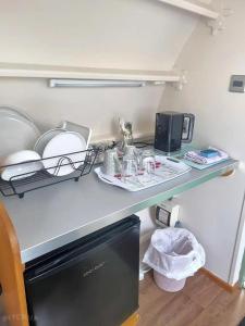 a kitchen counter with a counter top with dishes on it at Cosy 1 bedroom cabin- Moon Pod in Salisbury