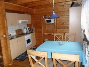 uma cozinha e sala de jantar com uma mesa azul e cadeiras em Ferienhaus Bliev-Hee Nr 3 em Klink