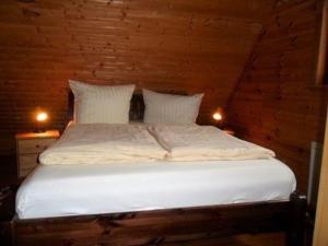 uma cama num quarto com duas luzes em Ferienhaus Bliev-Hee Nr 3 em Klink
