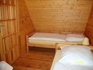 um pequeno quarto com 2 camas num chalé de madeira em Ferienhaus Bliev-Hee Nr 3 em Klink