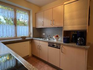 a kitchen with white cabinets and a sink at Ferienwohnung „Rosarium“ in Gunzenhausen