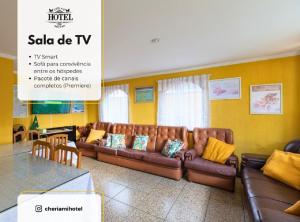 a living room with a brown couch and yellow walls at Cheri Ami Hotel in Joinville