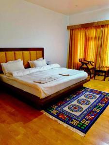 a bed in a bedroom with a rug on the floor at Niran Boutique Hotel in Leh
