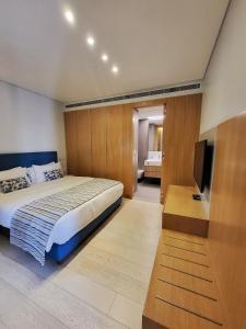 um quarto com uma cama e uma televisão de ecrã plano em Monot Suites em Beirute