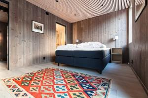 a bedroom with a bed and a rug on the floor at Stor moderne leilighet i Henningsvær, 70 kvm in Henningsvær