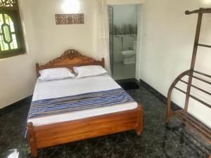 a bedroom with a bed and a toilet in a room at Kingz and Queenz - Negombo in Negombo